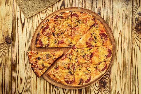 Hot pizza slice with melting cheese on a rustic wooden table.pepperoni pizza,Hot Homemade Pepperoni Pizza Ready to Eat,Supreme Pizza lifted slice,Delicious cheese stringy slice lifted of full supreme pizza,Margherita