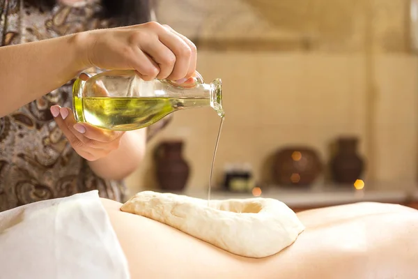Femme dans le spa de bien-être ayant massage aromatique avec huile essentielle, Femme bénéficiant d'un traitement de massage à l'huile ayurvédique dans un spa, Techniques de massage, massage du dos, Fille salon de massage aux herbes ayurvédiques — Photo