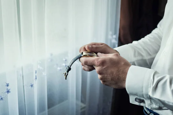 Hombre de negocios comprobar la hora en su reloj de pulsera, hombre poniendo reloj en la mano, novio preparándose en la mañana antes de la ceremonia de boda — Foto de Stock