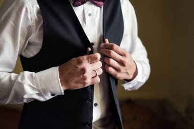 İş adamı ceket giyiyor, erkek eli kapalı, damat düğün töreninden önce hazırlanıyor.