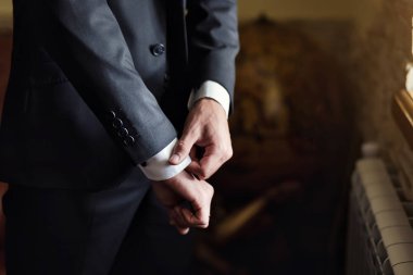 İş adamı ceket giyiyor, erkek eli kapalı, damat düğün töreninden önce hazırlanıyor.