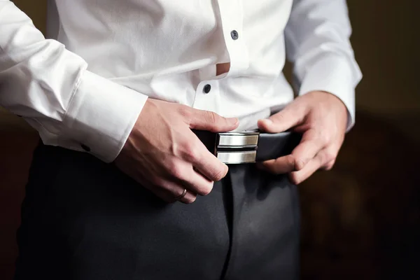 Homme d'affaires portant une ceinture, concept de mode et de vêtements, marié se préparer le matin avant la cérémonie — Photo