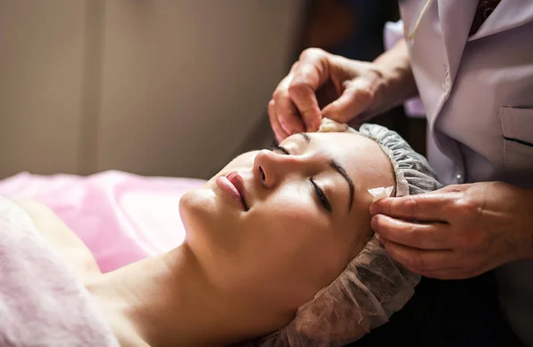 Mujer recibiendo cuidado facial mascarilla peladora por esteticista en el salón de spa —  Fotos de Stock