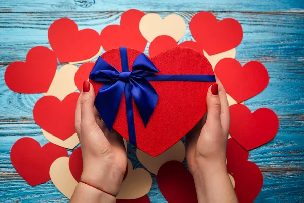 Жінки руки, що тримає подарунок подарунок коробка у формі серця / день Святого Валентина фону — стокове фото