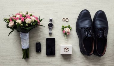 Bir iş adamının farklı aksesuarları ahşap bir arka planda yatar.