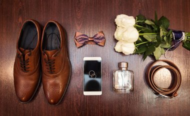 Bir iş adamının farklı aksesuarları ahşap bir arka planda yatar.