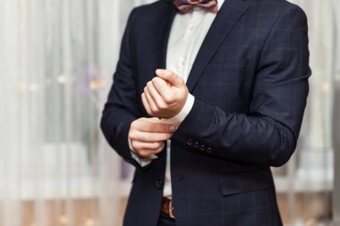 İş adamı ceket giyiyor, erkek eli kapalı, damat düğün töreninden önce hazırlanıyor.