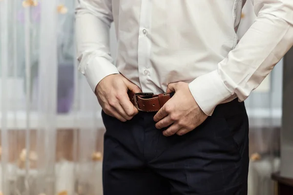 Empresario que se pone un cinturón, concepto de moda y ropa, novio preparándose en la mañana antes de la ceremonia — Foto de Stock