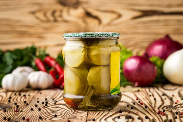 Composition of pickled marrows in jar and ingredients on wooden background — Stock Photo, Image