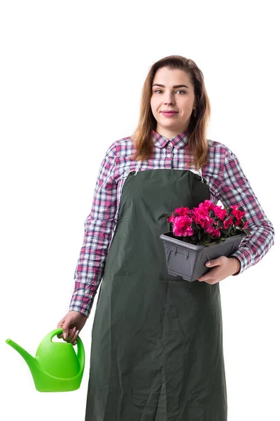 Portret van lachende vrouw professionele tuinman of bloemist in schort bloemen te houden in een pot en tuinieren hulpmiddelen geïsoleerd op witte achtergrond — Stockfoto