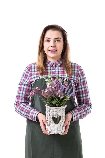 Portrait de femme souriante jardinier professionnel ou fleuriste dans un tablier tenant des fleurs dans un pot isolé sur fond blanc — Photo