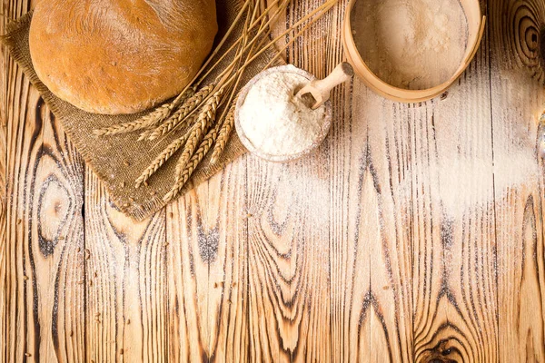 Pan con harina de trigo, espigas y granos sobre mesa de madera. Concepto de agricultura y cosecha. Foto con área de espacio de copia para un texto —  Fotos de Stock