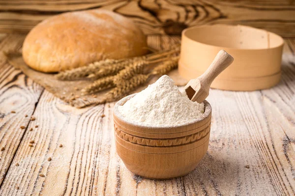 Хліб з пшеничним борошном, шипами і зернами на дерев'яному столі. Концепція сільського господарства та збору врожаю . — стокове фото