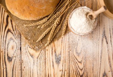 Ekmek buğday unu, sivri ve tahıl ahşap masa üzerinde. Tarım ve hasat kavramı. Fotoğraf kopyalama alanı alanı bir metin için ile