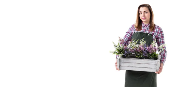 Ritratto di donna sorridente giardiniere professionista o fiorista in grembiule che tiene fiori in una pentola isolata su sfondo bianco. Copia spazio — Foto Stock