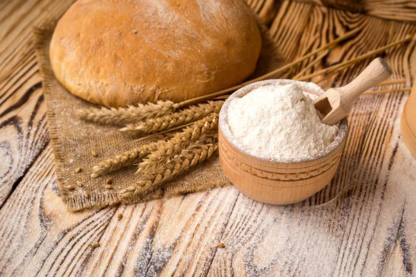 Pan con harina de trigo, espigas y granos sobre mesa de madera. Concepto de agricultura y cosecha . —  Fotos de Stock