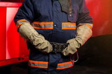 İtfaiyeci (itfaiye) eylem daimi bir firetruck yakınındaki. Acil durum Emanet. Koruma, tehlikeden kurtarmak.