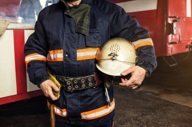 İtfaiyeci (itfaiye) eylem daimi bir firetruck yakınındaki. Acil durum Emanet. Koruma, tehlikeden kurtarmak.