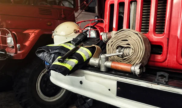 Equipamento de bombeiros em caminhão de bombeiros, como barril de incêndio, roupas especiais, ração, capacete e hidrante — Fotografia de Stock