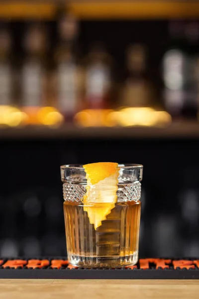 Vaso de whisky (coñac o brandy) con cubos de limón y hielo en el mostrador de la barra —  Fotos de Stock