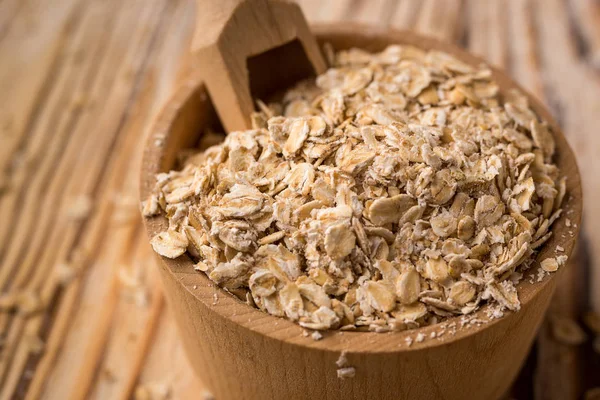 Вівсяна крупа в мисці на дерев'яному фоні. Концепція здорового харчування зернових . — стокове фото