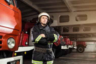 İtfaiyeci (itfaiye) eylem daimi bir firetruck yakınındaki. Acil durum Emanet. Koruma, tehlikeden kurtarmak.