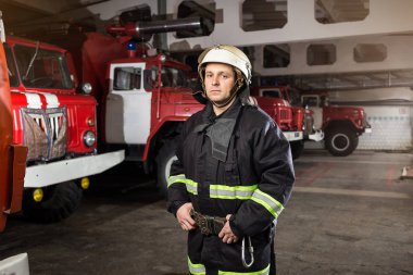 İtfaiyeci (itfaiye) eylem daimi bir firetruck yakınındaki. Acil durum Emanet. Koruma, tehlikeden kurtarmak.