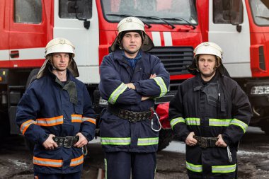 İtfaiyeci (itfaiye) eylem daimi bir firetruck yakınındaki. Acil durum Emanet. Koruma, tehlikeden kurtarmak.