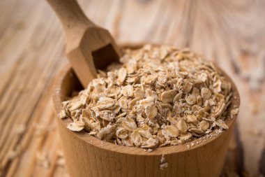 Ahşap arka plan üzerinde kapta yulaf kabuğu çıkarılmış tane. Sağlıklı Diyet hububat kavramı.