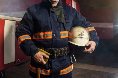 İtfaiyeci (itfaiye) eylem daimi bir firetruck yakınındaki. Acil durum Emanet. Koruma, tehlikeden kurtarmak.