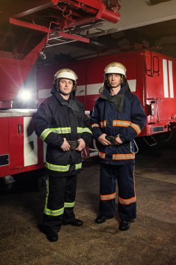 İtfaiyeci (itfaiye) eylem daimi bir firetruck yakınındaki. Acil durum Emanet. Koruma, tehlikeden kurtarmak.