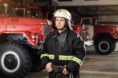 İtfaiyeci (itfaiye) eylem daimi bir firetruck yakınındaki. Acil durum Emanet. Koruma, tehlikeden kurtarmak.