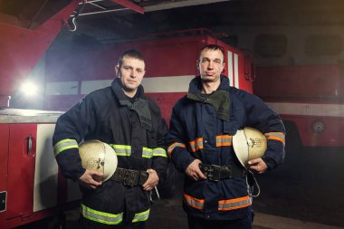 İtfaiyeci (itfaiye) eylem daimi bir firetruck yakınındaki. Acil durum Emanet. Koruma, tehlikeden kurtarmak.