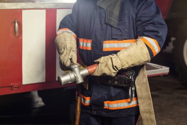 İtfaiyeci (itfaiye) eylem daimi bir firetruck yakınındaki. Acil durum Emanet. Koruma, tehlikeden kurtarmak.