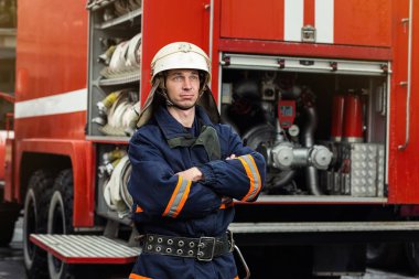 İtfaiyeci (itfaiye) eylem daimi bir firetruck yakınındaki. Acil durum Emanet. Koruma, tehlikeden kurtarmak.