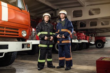 İtfaiyeci (itfaiye) eylem daimi bir firetruck yakınındaki. Acil durum Emanet. Koruma, tehlikeden kurtarmak.