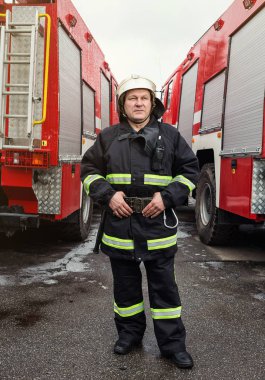 İtfaiyeci (itfaiye) eylem daimi bir firetruck yakınındaki. Acil durum Emanet. Koruma, tehlikeden kurtarmak.