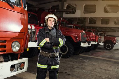 İtfaiyeci (itfaiye) eylem daimi bir firetruck yakınındaki. Acil durum Emanet. Koruma, tehlikeden kurtarmak.