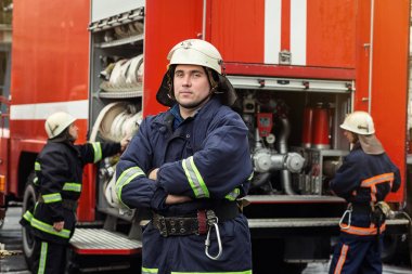 İtfaiyeci (itfaiye) eylem daimi bir firetruck yakınındaki. Acil durum Emanet. Koruma, tehlikeden kurtarmak.