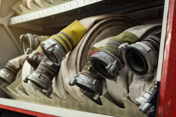 Komorze zwinięte węże pożarowe na fireengine. Awaryjnych bezpieczeństwa. Ochrony, ratunek przed niebezpieczeństwem. — Zdjęcie stockowe