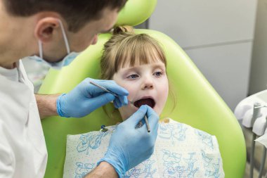 Küçük kızın diş Kliniği inceleyerek dişçi. Diş sorunu.