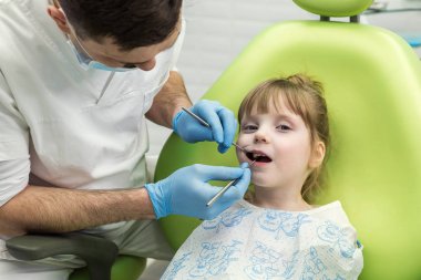 Küçük kızın diş Kliniği inceleyerek dişçi. Diş sorunu.