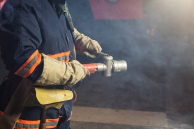 İtfaiyeci (itfaiye) eylem daimi bir firetruck yakınındaki. Emer