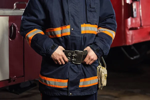 İtfaiyeci (itfaiye) eylem daimi bir firetruck yakınındaki. Emer