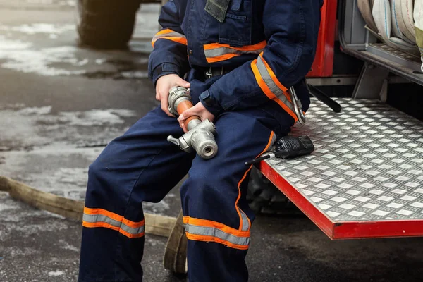 Brandweerman (brandweerman) in actie staande in de buurt van een brandweerwagen. Emer — Stockfoto