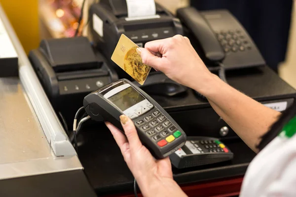 Mulher mão com cartão de crédito deslizar através do terminal para venda, em — Fotografia de Stock