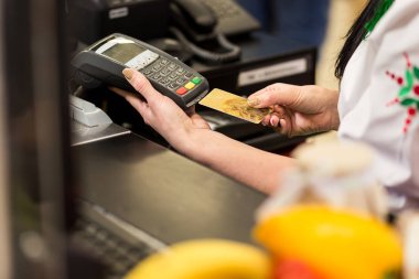 Kadın el ile kredi kartı swipe pazarında Satılık terminal aracılığıyla. Alışveriş ve perakende konsept