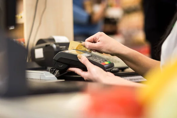 Mujer mano con tarjeta de crédito deslizar a través de terminal para la venta, en el mercado. Compras y concepto minorista — Foto de Stock