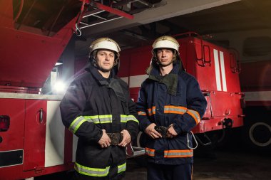 İtfaiyeci (itfaiye) eylem daimi bir firetruck yakınındaki. Emer