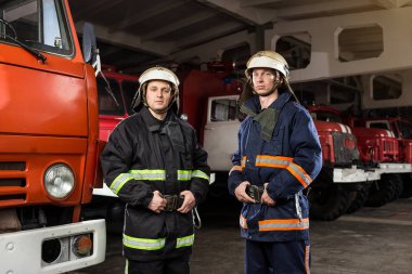 İtfaiyeci (itfaiye) eylem daimi bir firetruck yakınındaki. Emer
